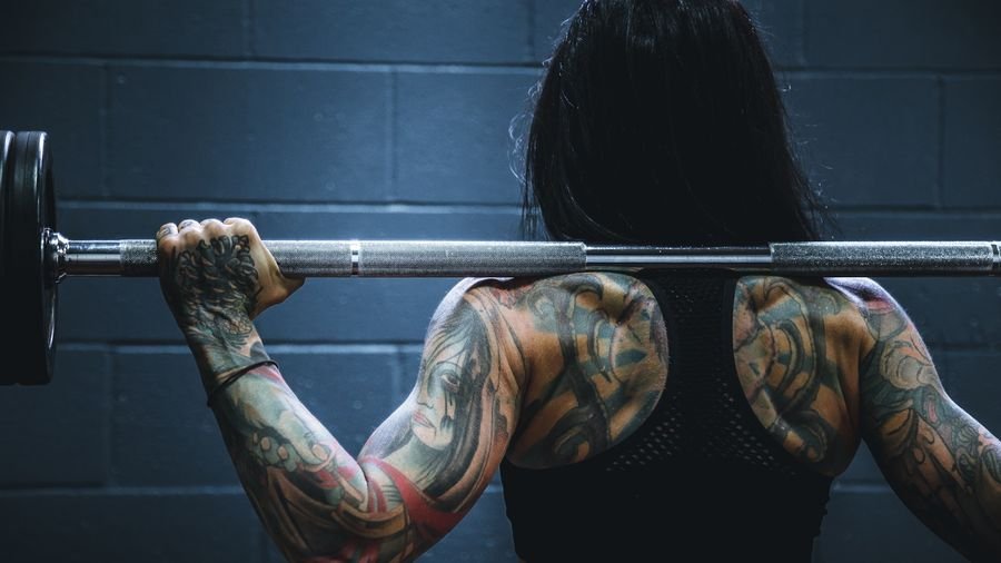 Coach spotting a member through a heavy bench press set