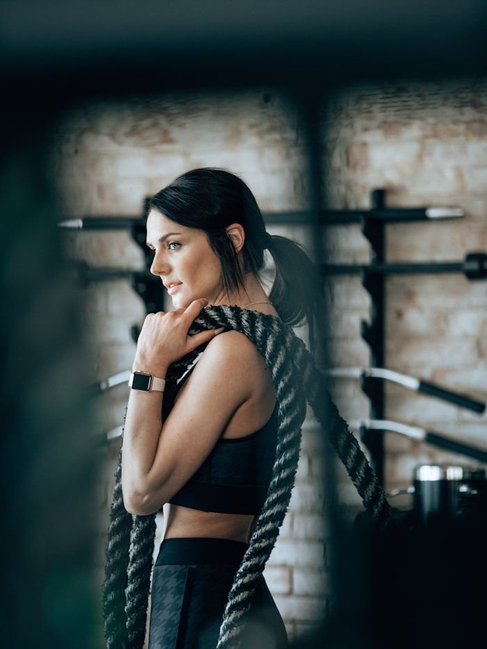 Portrait of conditioning coach Emily Davis holding a battle rope